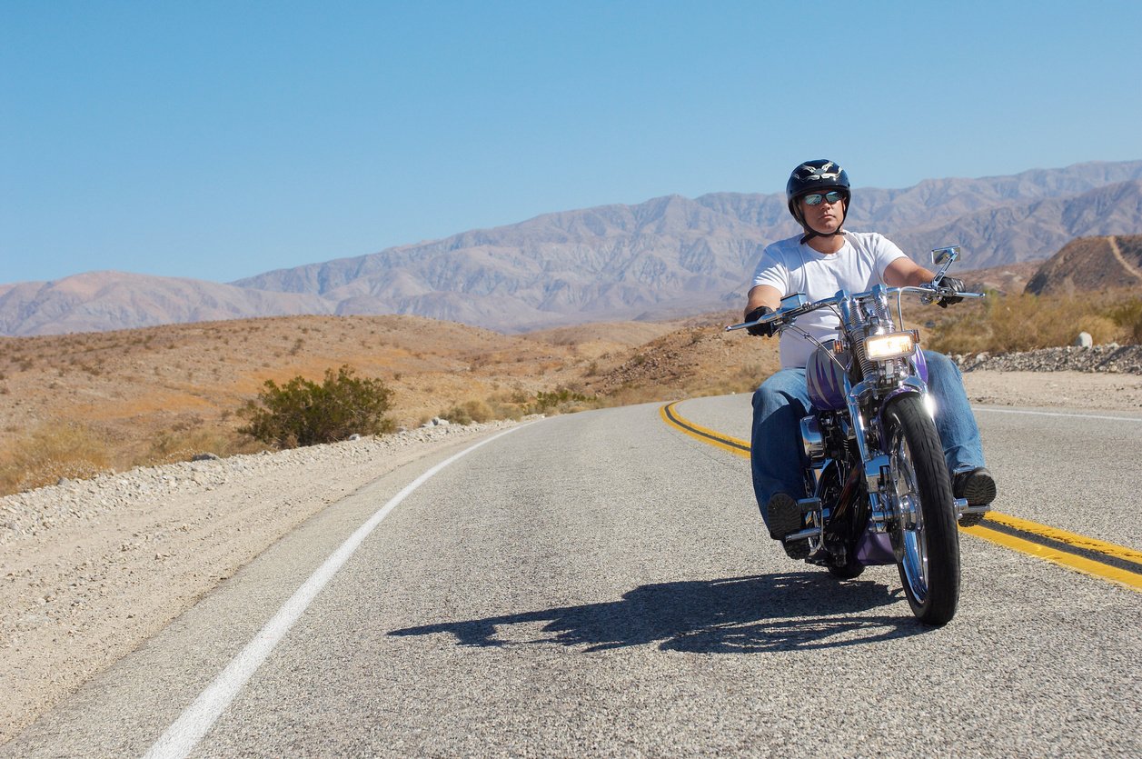 Man riding motorcycle on desert road